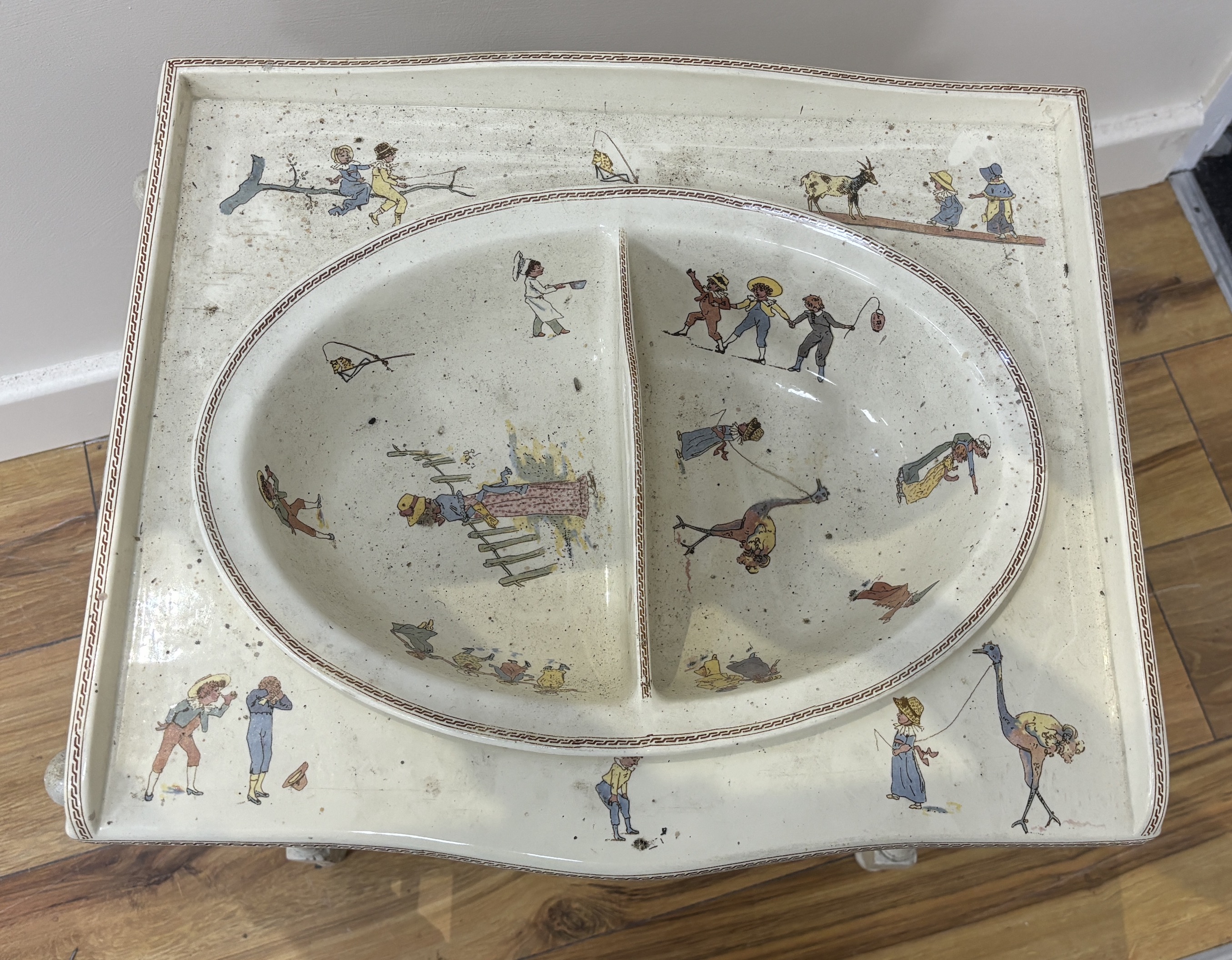 A French Sarreguemines pottery child's basin decorated with nursery scenes and matching wash stand, 51 x 37 x 48cm